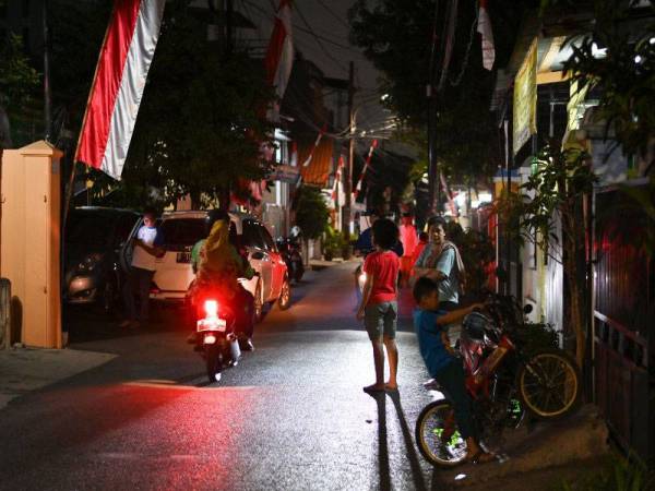 Penduduk tempatan keluar daripada kediaman masing-masing selepas Jakarta digegarkan dengan gempa berukuran 7.4 skala Richter. - Foto AFP