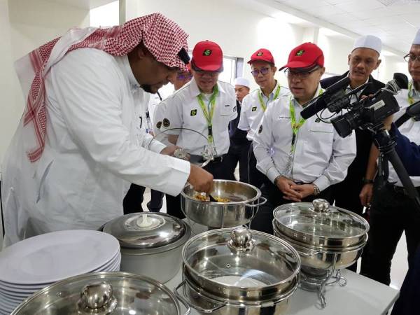 Ketua Rombongan Haji Malaysia, Datuk Seri Syed Saleh Syed Abd Rahman (tiga dari kanan) melihat makanan disediakan daripada pek makanan 'makanan sedia dimakan' di kilang Taj Food di sini hari ini. - Foto Bernama 