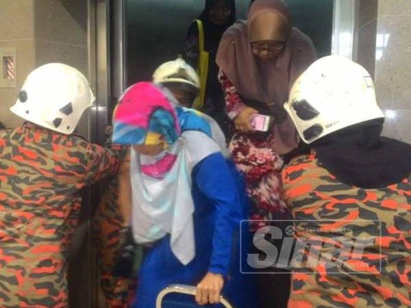 Anggota bomba membantu mengeluarkan semua mangsa selepas pintu lif berjaya dibuka menggunakan peralatan khas. 