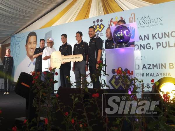 Mohamed Azmin (tengah) menyampaikan replika kunci kepada pembeli Casa Anggun tadi.