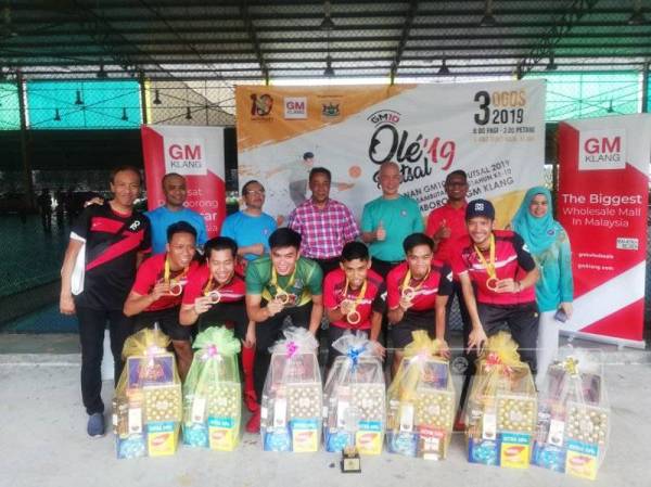 Lim (belakang, tiga dari kanan) dan Yang Dipertua MPK, Datuk Mohamad Yasid Bidin (belakang, empat dari kanan) bersama pasukan MPK yang muncul juara kategori lelaki GM10 Ole Futsal 2019.