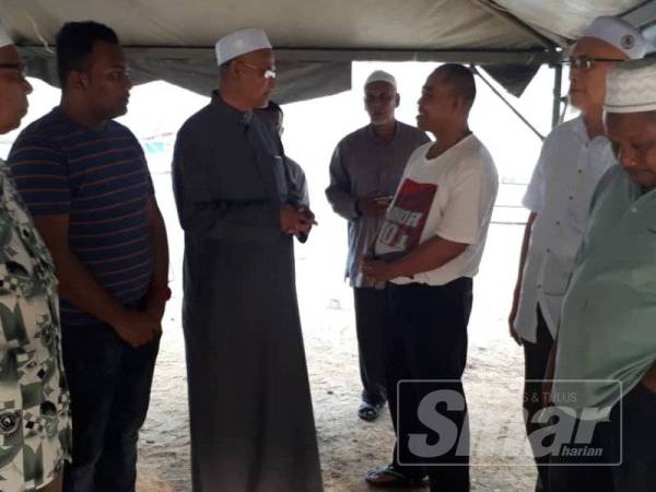 Wan Hassan (tiga dari kiri) melawat keluarga mangsa di Jeti A'king Kuala Dungun hari ini.