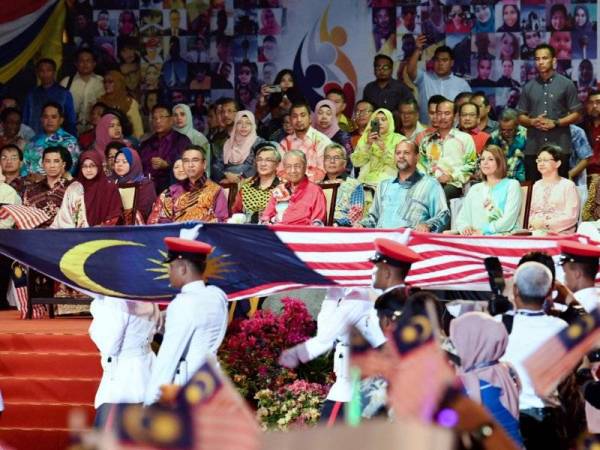 Dr Mahathir (duduk, tengah) melihat upacara membawa masuk Jalur Gemilang oleh 3 Rejimen Kor Polis Tentera Diraja pada Pelancaran Bulan Kebangsaan dan Kibar Jalur Gemilang 2019 di Dataran Pahlawan malam ini.