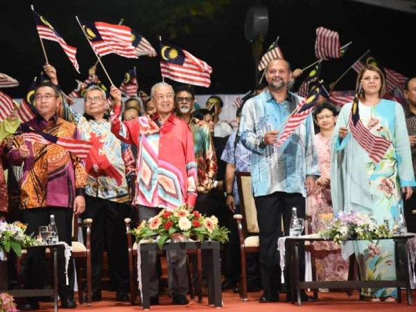 Gobind bersama Perdana Menteri, Tun Dr Mahathir Mohamad mengibarkan Jalur Gemilang pada pelancaran program tersebut malam tadi. - Foto IHSAN JABATAN PENERANGAN