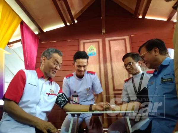 Dzulkefly (kiri) dan Mohd Anuar turut melakukan pemeriksaan tekanan darah sempena perasmian program tersebut di Dewan Terbuka Taman Pulai Idaman di Kampung Padang Lalang di sini hari ini.