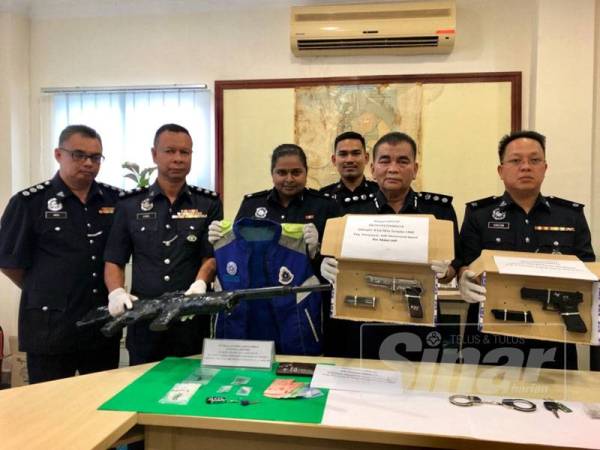 Abdul Rahim (dua dari kanan) bersama pegawainya menunjukkan dua pucuk pistol dan selaras senapang yang dirampas dari dua lelaki, Khamis lalu pada sidang media di IPD Kota Bharu hari ini.