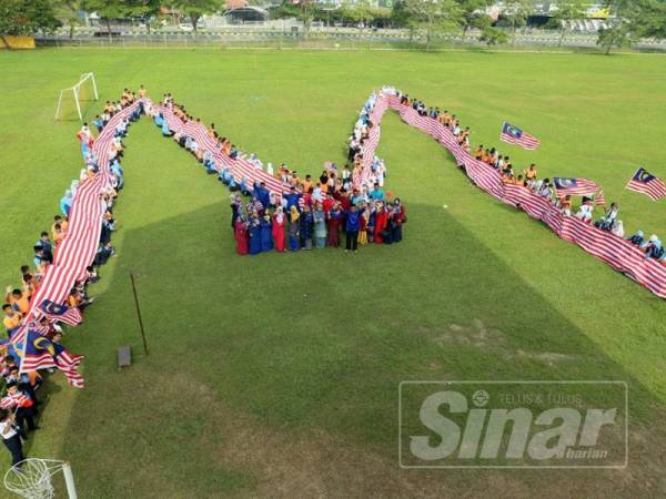 Warga SK Mergong membentuk perkataan 'M' yang melambangkan nama sekolah dengan membawa Jalur Gemilang dihasilkan menggunakan 36 pasang kain putih itu.