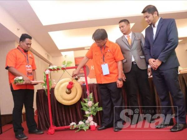 Hasnul Zulkarnain (kanan) menyaksikan gimik perasmian disempurnakan Asmuni.