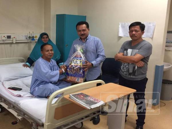 Mohd Yusri (tengah) menyerahkan cenderamata kepada anggota polis yang masih menerima rawatan di Hospital Bentong semalam.