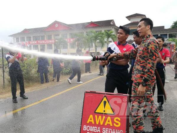 Pelajar diberi peluang mengendalikan hos bomba.