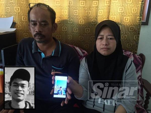 Md Azhar dan isteri, Zunaidah sayu ketika menunjukkan gambar Amirul Ashraff di telefon bimbit di kediaman mereka di sini hari ini. (Gambar kecil: Amirul)