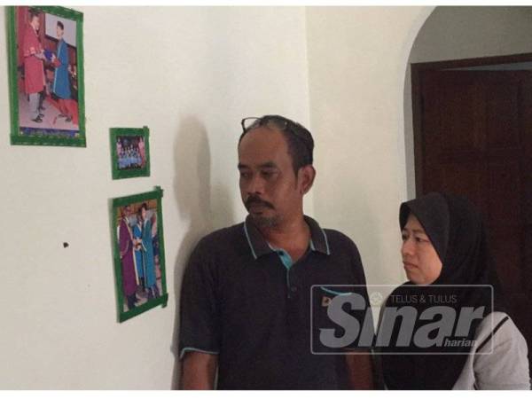 Md Azhar melihat gambar Amirul Ashraff ketika di bangku sekolah bersama isterinya Zunaidah Ahmad.