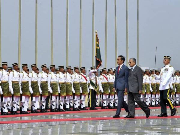 Perdana Menteri Tun Dr Mahathir Mohamad (dua, kanan) mengiringi Presiden Indonesia Joko Widodo memeriksa barisan kehormat daripada Batalion Pertama Rejiman Askar Melayu Diraja semasa sambutan rasmi di Dataran Perdana, Bangunan Perdana Putra pada lawatan rasmi Presiden Indonesia itu ke Malaysia hari ini. - Foto Bernama 