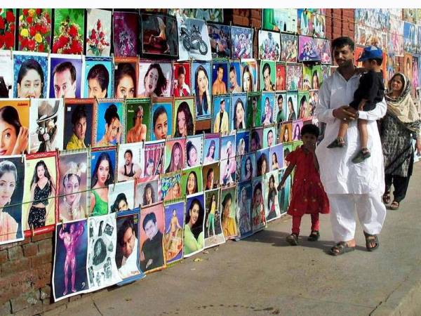 Poster bintang Bollywood dijual di sepanjang kaki lima di Karachi, Pakistan.