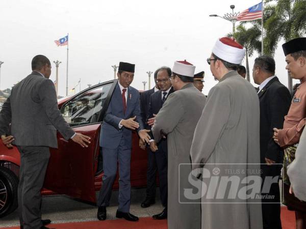 Presiden Indonesia, Joko Widodo ketika tiba di pekarangan Masjid Putra bagi menunaikan Solat Jumaat pada lawatan kerja, di sini hari ini.
