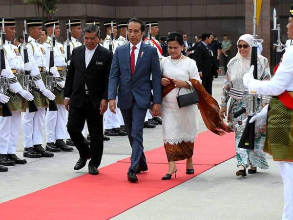 Presiden Indonesia Joko Widodo dan isteri, Iriana Joko Widodo melintasi kawalan kehormat sebelum berlepas ke Singapura dari Kompleks Bunga Raya Lapangan Terbang Antarabangsa Kuala Lumpur hari ini selepas menamatkan lawatan rasmi ke Malaysia selama dua hari. - Foto BERNAMA