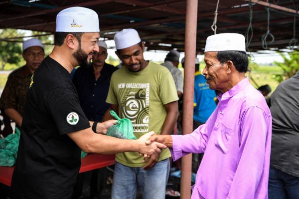 Menteri Besar Kedah Datuk Seri Mukhriz Tun Dr Mahathir mengagihkan daging korban kepada fakir miskin pada Program Korban di Masjid Pida 3 Jitra hari ini. -Foto Bernama