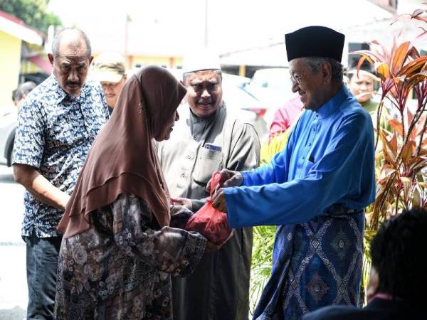 Perdana Menteri Tun Dr Mahathir Mohamad menyampaikan daging korban kepada asnaf ketika hadir pada Majlis Ramah Mesra Penduduk Kedawang sempena Majlis Korban di Masjid Ar-Rahman Kedawang hari ini. - Foto Bernama