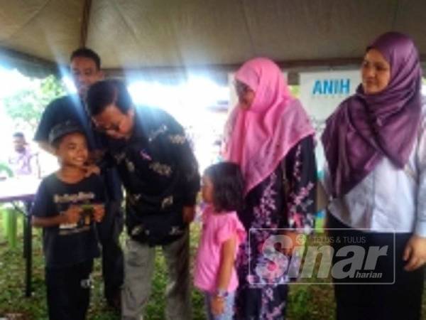 Mohd Anuar (tiga dari kanan) bertanyakan sesuatu kepada kanak-kanak yang turut menerima sumbangan wang tunai sempena program tersebut.