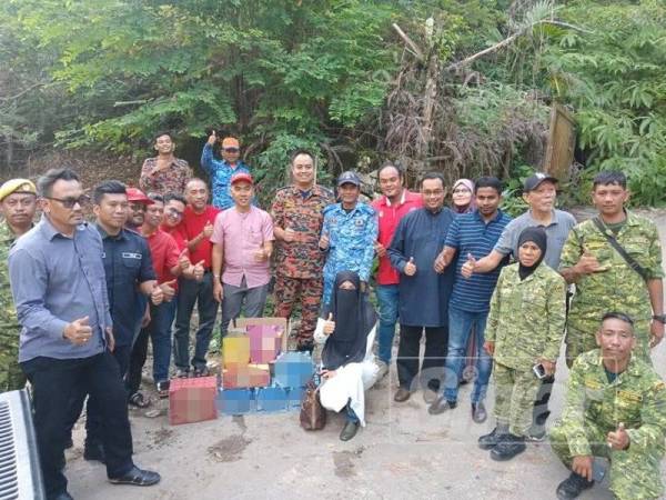 Muhammad Aziim (lapan dari kiri) ketika menyerahkan sumbangan kepada pasukan SAR semalam.