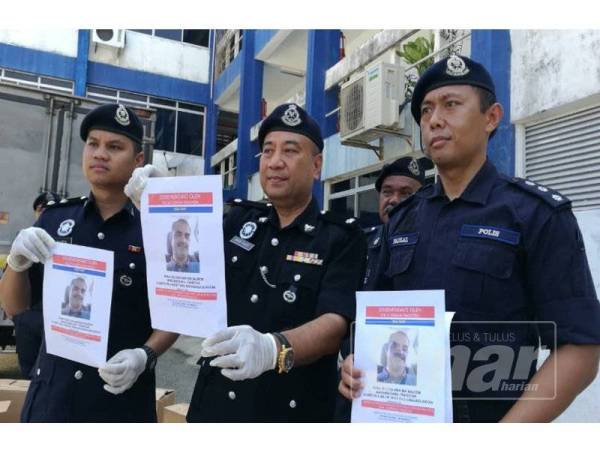 Wan Fauzi (tengah) menunjukkan gambar suspek yang diburu selepas menetak bekas isteri dan suami,1 Ogos lalu.