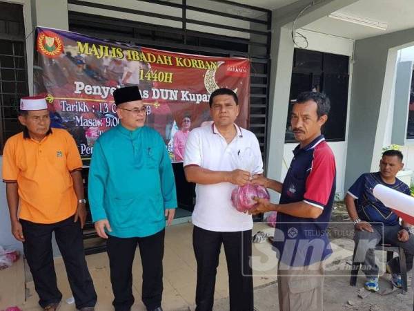 Mohd Taufik (dua dari kanan) menyampaikan agihan daging korban kepada penerima.