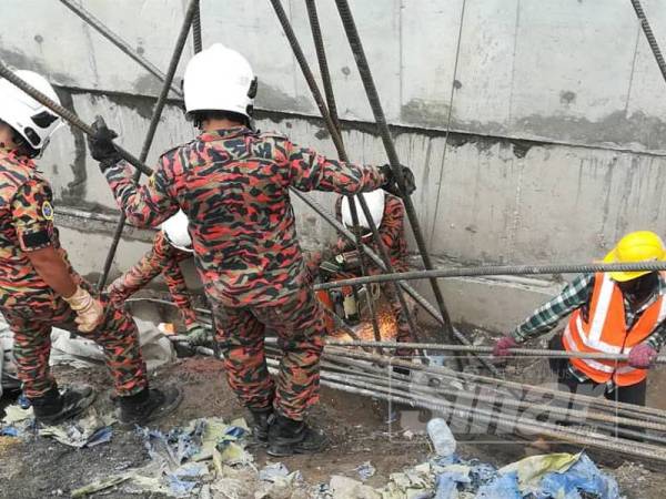 Anggota bomba menjalankan kerja mengalihkan timbunan besi cerucuk konkrit di tempat kejadian bagi mengeluarkan mangsa.