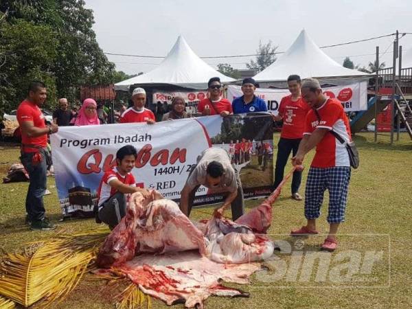 Mohd Hashrul (kiri) berganding bahu bersama rakan niaga dan AJK Surau Bukit Mentok bagi menjayakan Program Red Qurban.