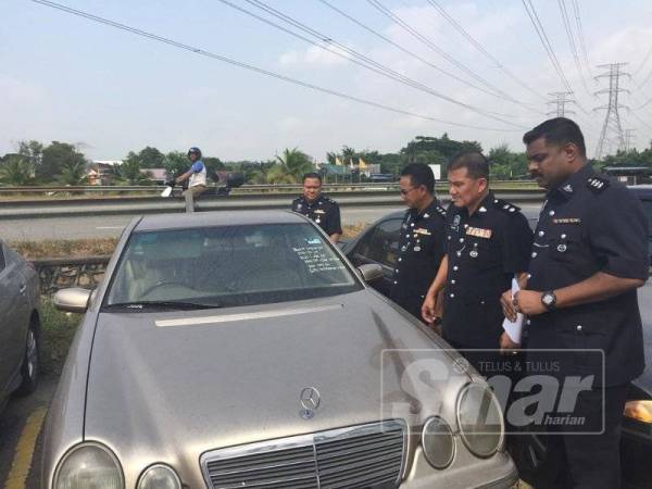 Ibrahim (dua kanan) melihat antara kereta yang dirampas.