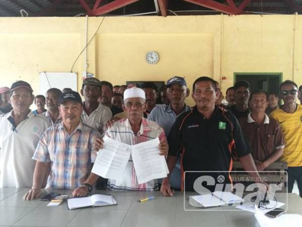 Mansor (depan) bersama nelayan di Pengkalan Penghulu mendesak campur tangan kerajaan negeri selesaikan tuntutan nelayan yang terjejas akibat projek tambakan di Tanjung Piai.