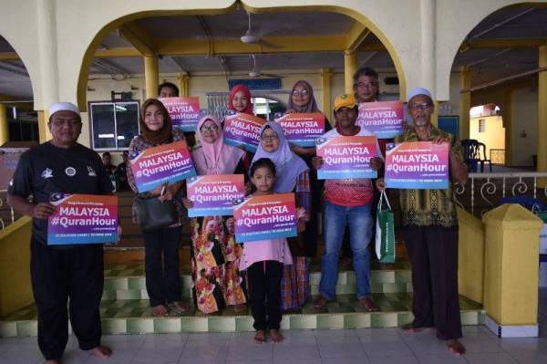 USTAZ HASBULLAH (depan, kiri) bersama kariah Kampung Melaka Pindah memberi sokongan kepada kempen Malaysia #QuranHour pada program Jom Cuci Masjid Siri ke-34 baru-baru ini.