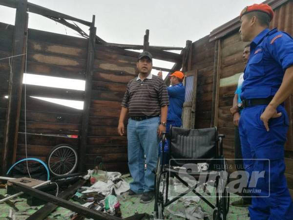 Romli meninjau sebuah kediaman mengalami kerosakan akibat bencana ribut Lekima di Kampung Kubang Panggas, Kubang Rotan di sini tadi.