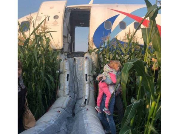 Penumpang dibawa keluar menerusi laluan kecemasan selepas pesawat Airbus Rusia membawa lebih 230 penumpang terpaksa melakukan pendaratan cemas di atas ladang jagung di pinggir Moscow hari ini.