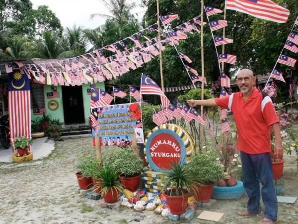 Demi menyemarakkan Sambutan Bulan Kebangsaan tahun ini, Mohd Daud Rasol 59, menggantungkan Jalur Gemilang pelbagai saiz serta replika yang dihasilkan dengan begitu kreatif dan menarik di hadapan rumahnya di Kampung PPRT Larut Permai, Air Kuning dekat sini. - Foto Bernama
