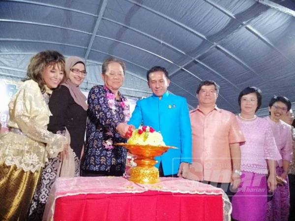 Mohamaddin (tiga kiri) memotong pulut semangat sebagai gimik perasmian sempena Festival Citrawarna Siam Malaysia 2019 di Wat Machimmaram Kampung Jubakar di sini malam tadi.