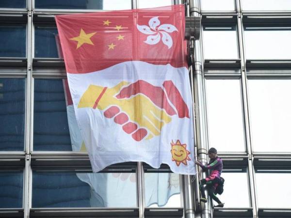 'Spiderman Perancis' memasang 'sepanduk keamanan' di bangunan Pusat Cheung Kong di Hong Kong, hari ini. - Foto AFP