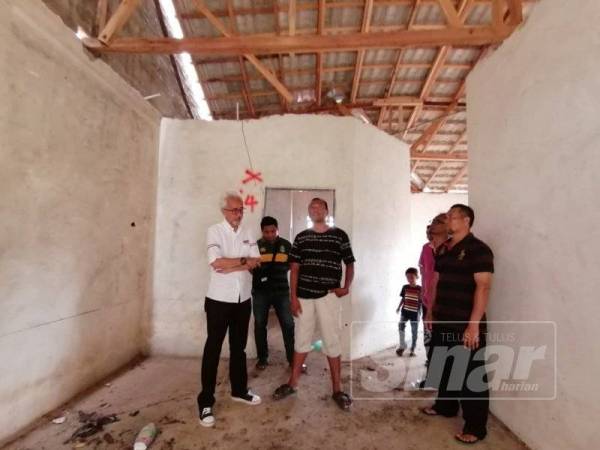 Raja Kamarul Bahrin Shah (kiri) meninjau masalah isu projek perumahan terbengkalai di Padang Setengge, Hulu Terengganu.