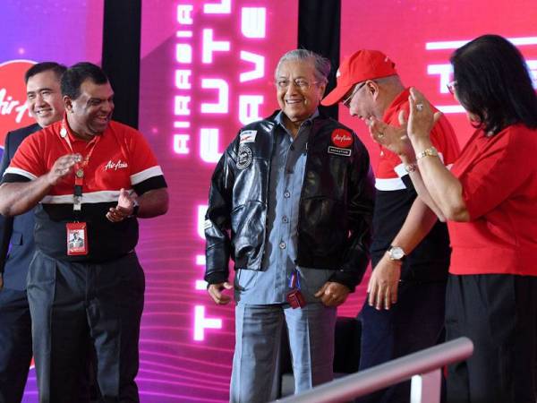 Tun Dr Mahathir (tengah) mengenakan jaket kulit yang diterimanya semasa mengadakan lawatan ke Ibu Pejabat AirAsia, RedQ di Lapangan Terbang Antarabangsa Kuala Lumpur 2 (KLIA2) hari ini. - Foto Bernama