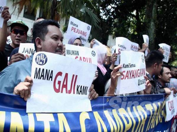 Sebahagian kakitangan Utusan Melayu mengadakan piket secara aman menuntut bayaran gaji tertunggak di hadapan ibu pejabat Utusan di Jalan Chow Sow Lin Kuala Lumpur di sini semalam. - Foto ZAHID IZZANI