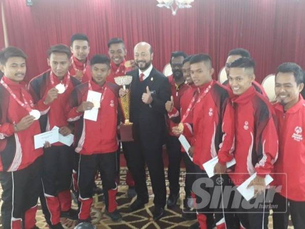 Mukhriz (tengah) bergambar bersama pasukan bola sepak Persatuan Olimpik Khas Kedah selepas majlis penghargaan di Wisma Darul Aman hari ini.