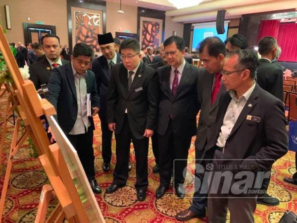 Chen Choon (empat dari kanan) dan Amran (tiga dari kanan) ketika melihat pameran draf rancangan kawasan khas pada Majlis Pelancaran Program Publisiti dan Penyertaan Awam Draf Rancangan Kawasan Khas Kawasan Perindustrian Majlis Bandaraya Johor Bahru di Hotel KSL hari ini.