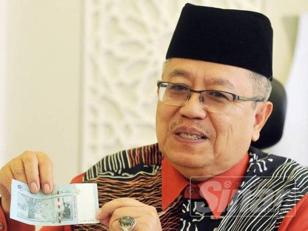 Datuk Mohamad Nordin Ibrahim menunjukkan wang kertas Malaysia yang mempunyai tulisan jawi. Foto: ROSLI TALIB