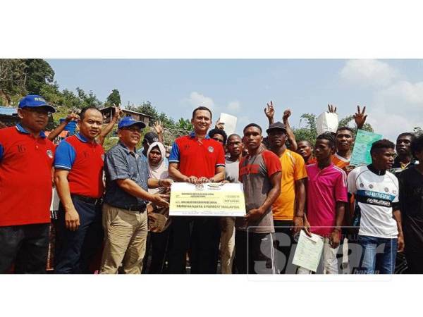 Hashim (tiga, kiri) bersama Khuzairi dalam program penyerahan sumbangan CSR SSM.