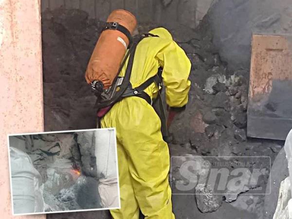 Anggota Hazmat mengasingkan bahan kimia yang belum terbakar.