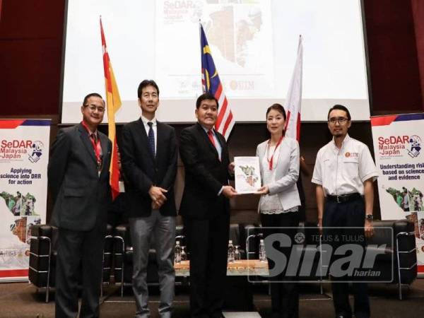 Loy Sian (tengah) menerima salinan buku laporan sebagai gimik pelancaran Majlis Penyerahan Buku Laporan daripada Universiti Tohoku kepada kerajaan negeri di Pusat Konvensyen Shah Alam, di sini hari ini.