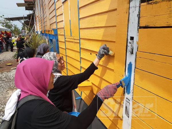 Warga PKNS bergotong royong mengecat salah sebuah rumah penerima dalam program ini di Jalan Pulai Kanchong Darat, Banting.