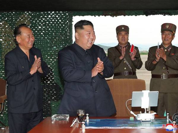 Jong-un (dua dari kiri) meraikan kejayaan ujian pelancaran senjata baharu yang dibangunkan Pyongyang. - Foto AFP