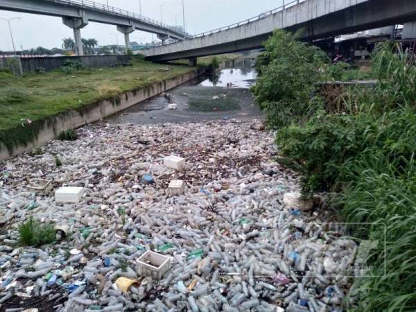 Keadaan Sungai Rasau yang dipenuhi sisa botol dan berada dalam keadaan kotor.