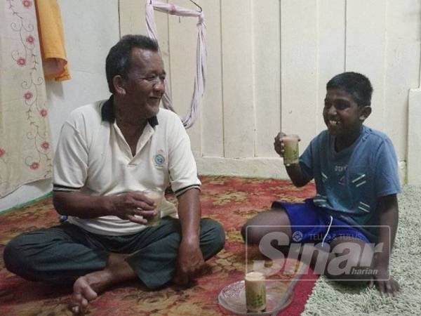 Mat Jatin (kiri) minum teh bersama Pararasan di rumahnya.