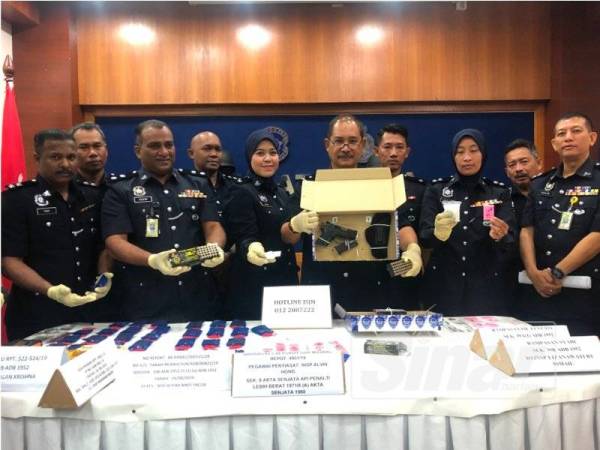 Abdullah (lima dari kanan) bersama anggota pegawai menunjukkan pistol dan dadah yang dirampas daripada empat suspek berkenaan.